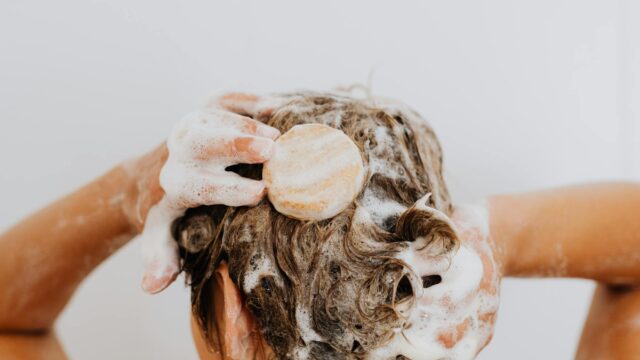 a person holding hair with soap