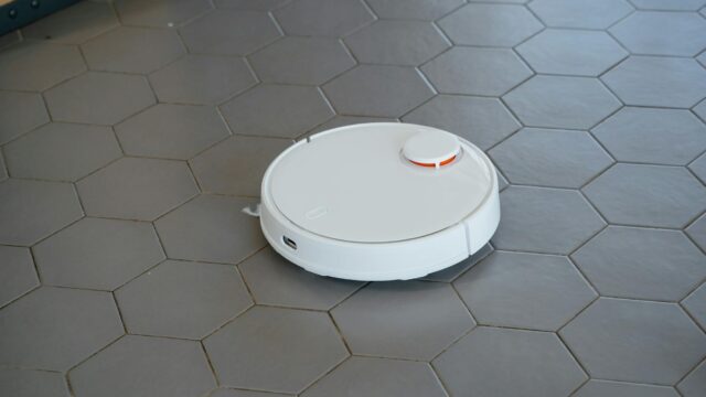 white round robot vacuum on gray tiled floor