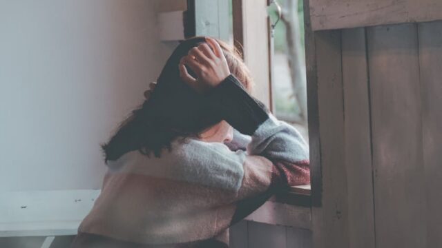 photo of a person leaning on wooden window