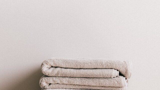 stack of fresh gray towels on white stool