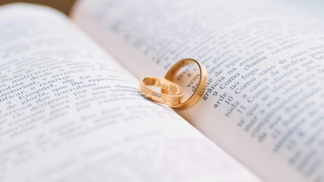 two gold colored wedding bands on book page